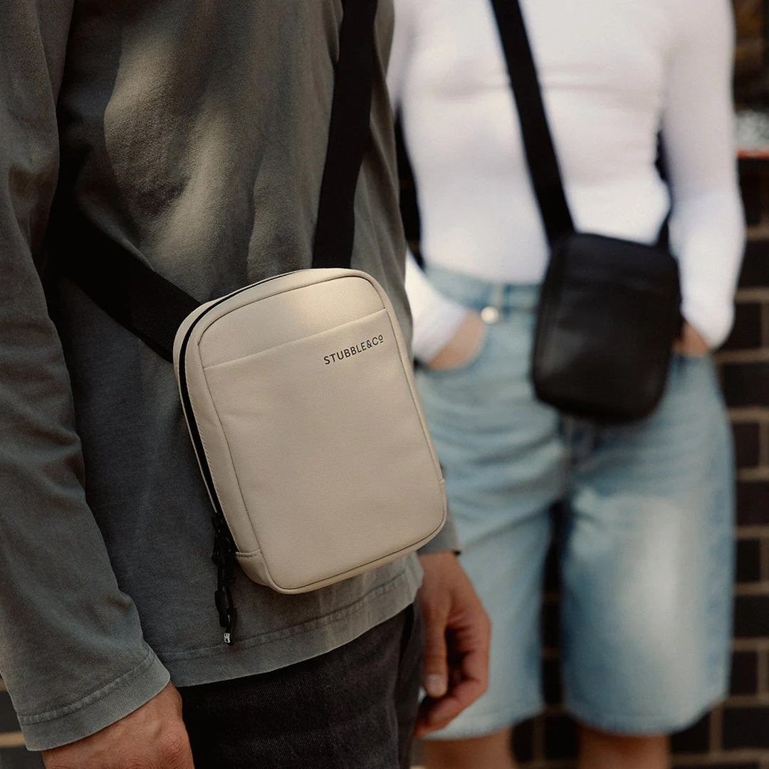 Sand waterproof shoulder bag worn on shoulder with black strap and small zip pouch