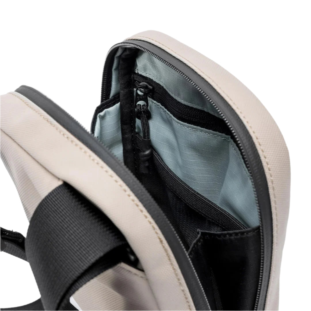 Sand waterproof shoulder bag open top showing zipper track, black pocket and light blue lining