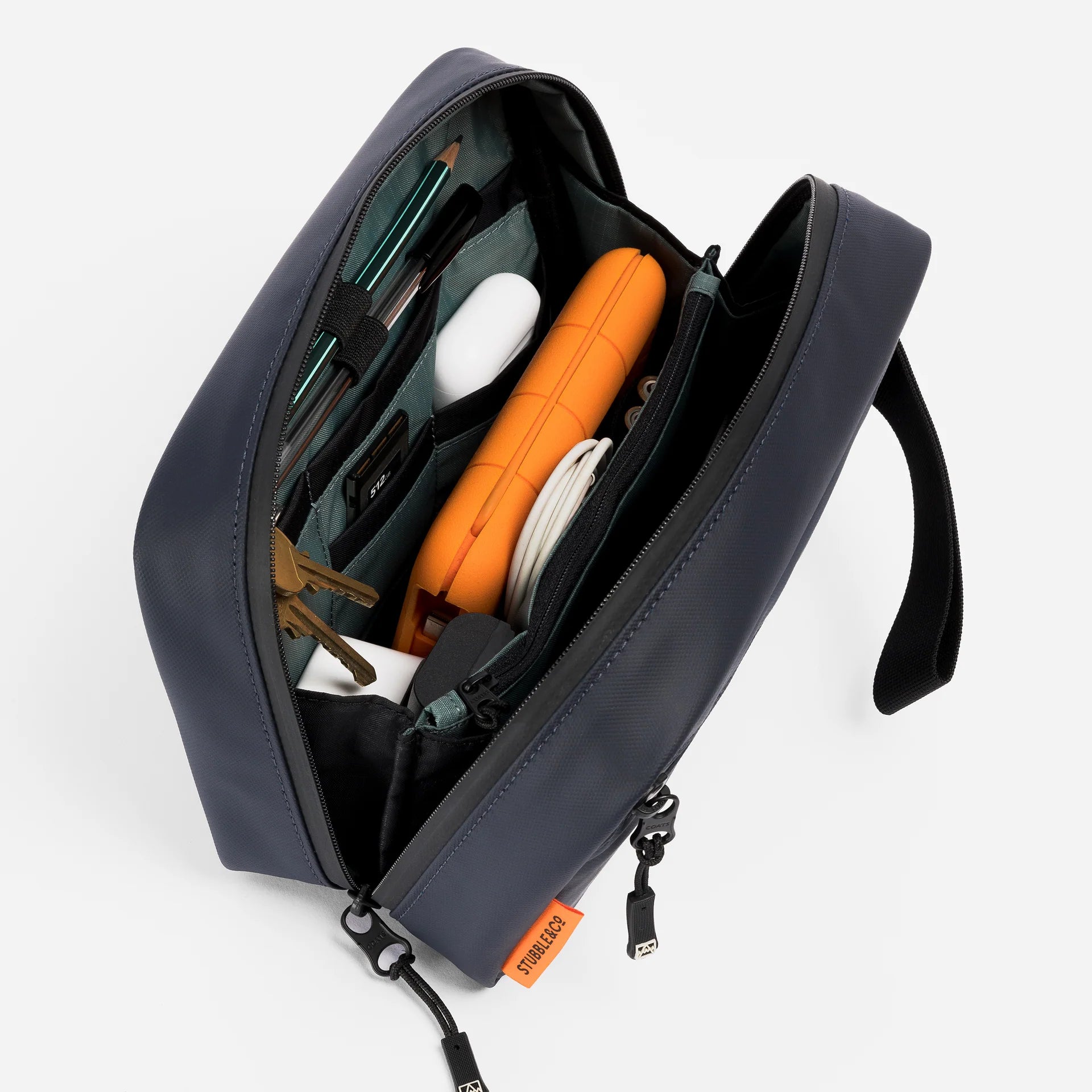 Waterproof tech bag open with interior pockets and gear in dark blue