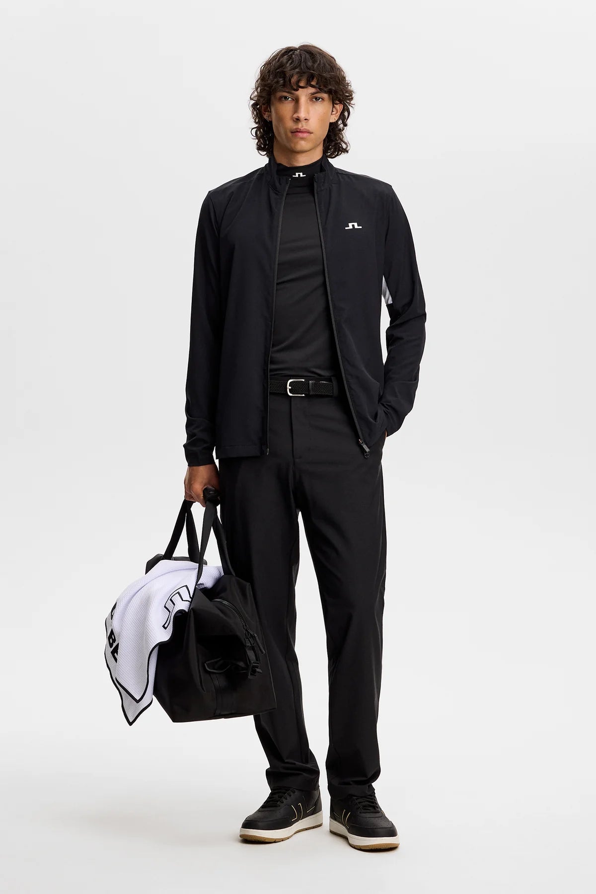 Black full-zip jacket with stand collar and chest JL logo, worn with black pants.