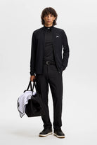 Black full-zip jacket with stand collar and chest JL logo, worn with black pants.