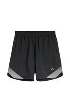 Black athletic shorts with elastic waistband and diagonal striped hem panel