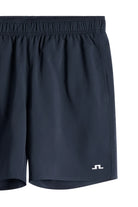 Navy athletic shorts close-up with elastic waistband and side logo patch