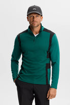 Men's teal quarter-zip mid layer with black side panels and stand collar