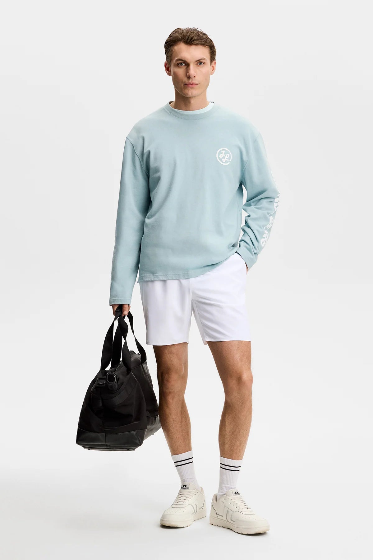 White pull-on shorts with elastic waistband and mid-thigh length on model.