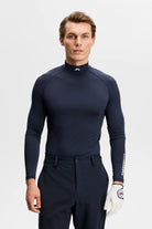 Navy mock-neck compression top with fitted long sleeves and sleeve logo