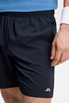 Navy athletic shorts fabric close-up with elastic waistband and side logo