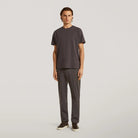 Dark brown tech stretch travel trousers on model, straight leg with cuffed hem