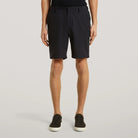 Black tech travel shorts on model, knee-length straight legs with belt loops