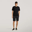 Black tech travel shorts on model, knee-length relaxed fit with belt loops
