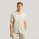 Light sand linen-cotton open collar short-sleeve shirt on model, button front