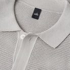 Stone grey knit polo collar close-up with button placket and brand label