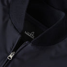 Hybrid bomber jacket close-up: metal zipper, ribbed knit collar, dark fabric
