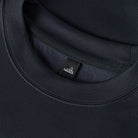 Deep navy crewneck sweater neckline with ribbed collar and Wahts label