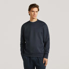Deep navy crewneck sweater on male model, long sleeves, ribbed cuffs and hem