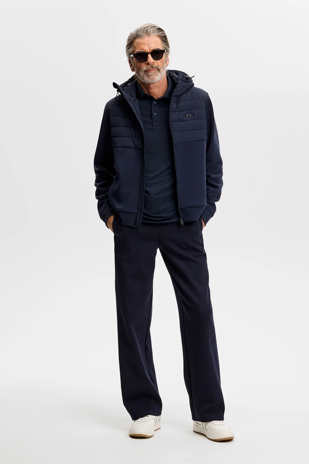 Navy long-sleeve polo shirt with buttoned placket and chest logo, worn under jacket