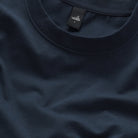 Deep navy crew-neck T-shirt close-up with logo label and stretch-knit texture