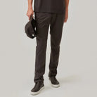 Model wearing dark brown tech trousers with side pocket and straight-leg fit