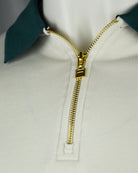 Polo quarter-zip with gold zipper and ribbed white placket, teal collar.