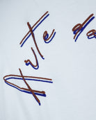 White T-shirt fabric with multicolor thread embroidered script detail