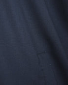 Navy jacket side panel close-up with contrast-stitched seam.