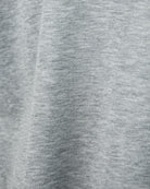 Heathered light grey T-shirt fabric close-up, knit texture detail.