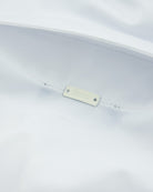 White polo shirt with small interior brand tag at the seam
