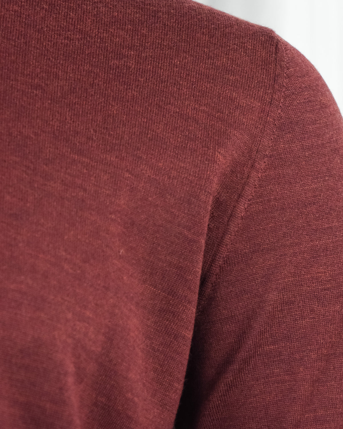 Burgundy knit sleeve with subtle shoulder seam and fine texture