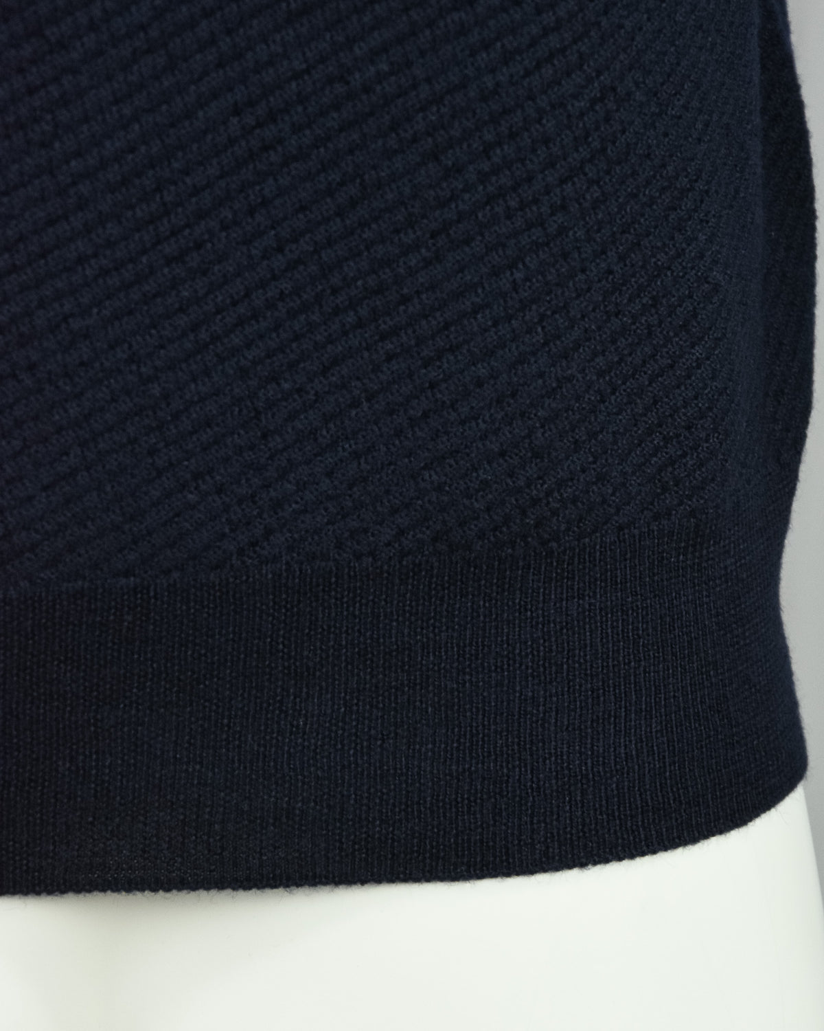 Navy knit polo hem with ribbed band and textured body
