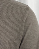 Taupe textured polo sleeve and side seam close-up