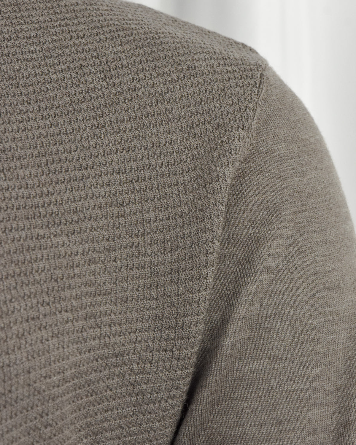 Taupe textured polo sleeve and side seam close-up