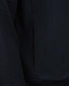 Detail view of dark navy front panel with stitched seam and zip placket