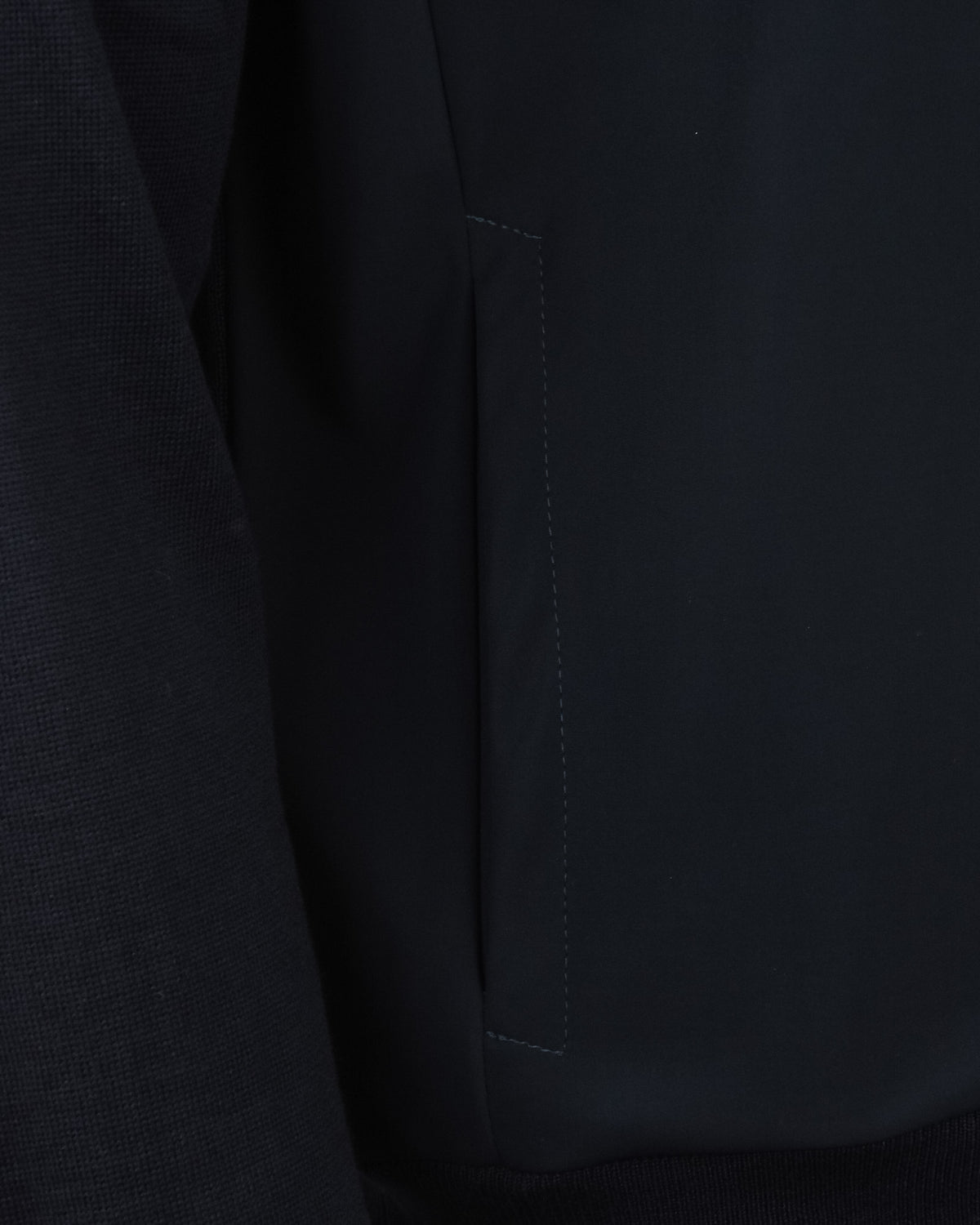 Detail view of dark navy front panel with stitched seam and zip placket