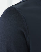 Close-up of dark navy knit sleeve texture on a smooth jacket panel