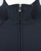 Stand collar close-up with dark navy zipper and metal branded pull tab
