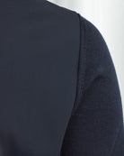 Side profile close-up showing dark navy knit sleeve trim and smooth front panel
