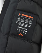 Black down parka interior label with Warming Level 1–4 icons