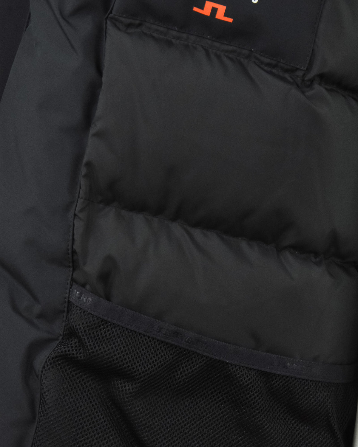 Black down parka interior with quilted lining and mesh inner pocket