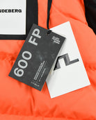 Down parka with attached 650 FP tag and white brand tag on orange fabric