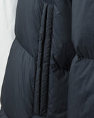 Dark navy crinkle down jacket with vertical welt pocket opening and ribbed trim