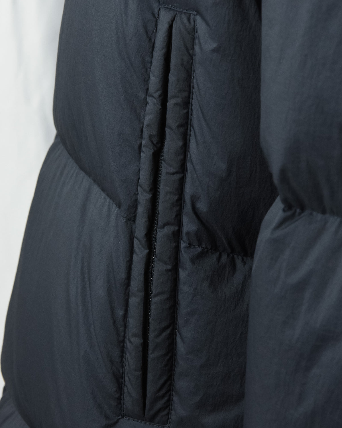 Dark navy crinkle down jacket with vertical welt pocket opening and ribbed trim
