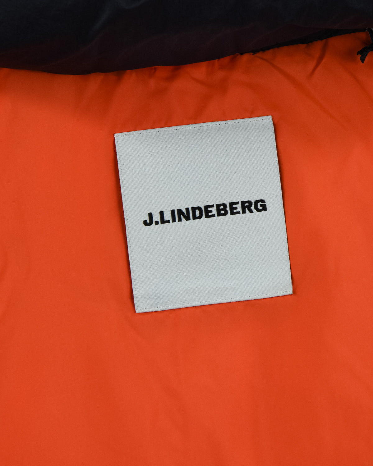 J.Lindeberg label on orange interior lining of the down jacket