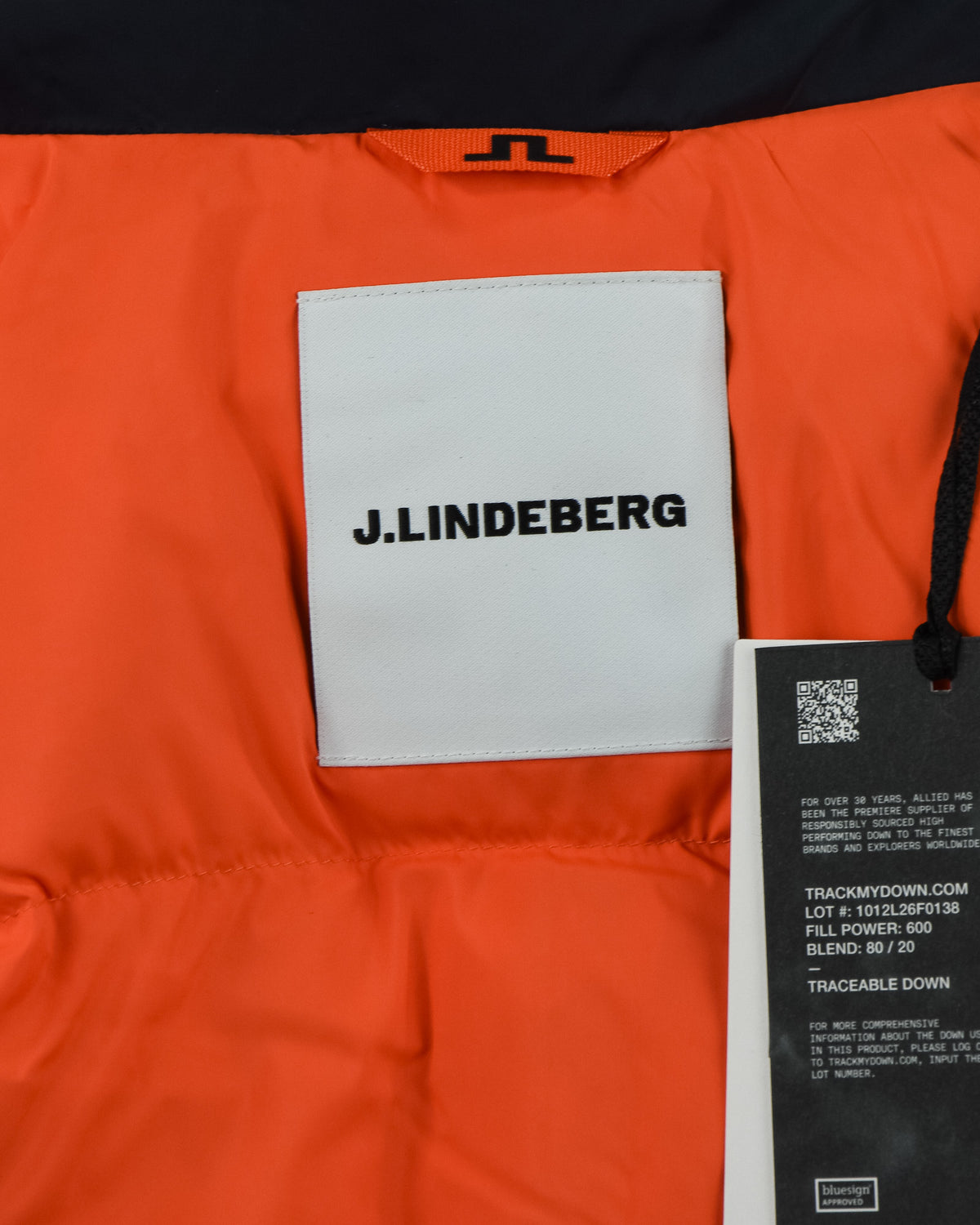 Orange interior lining with J.Lindeberg garment tag and black barcode label
