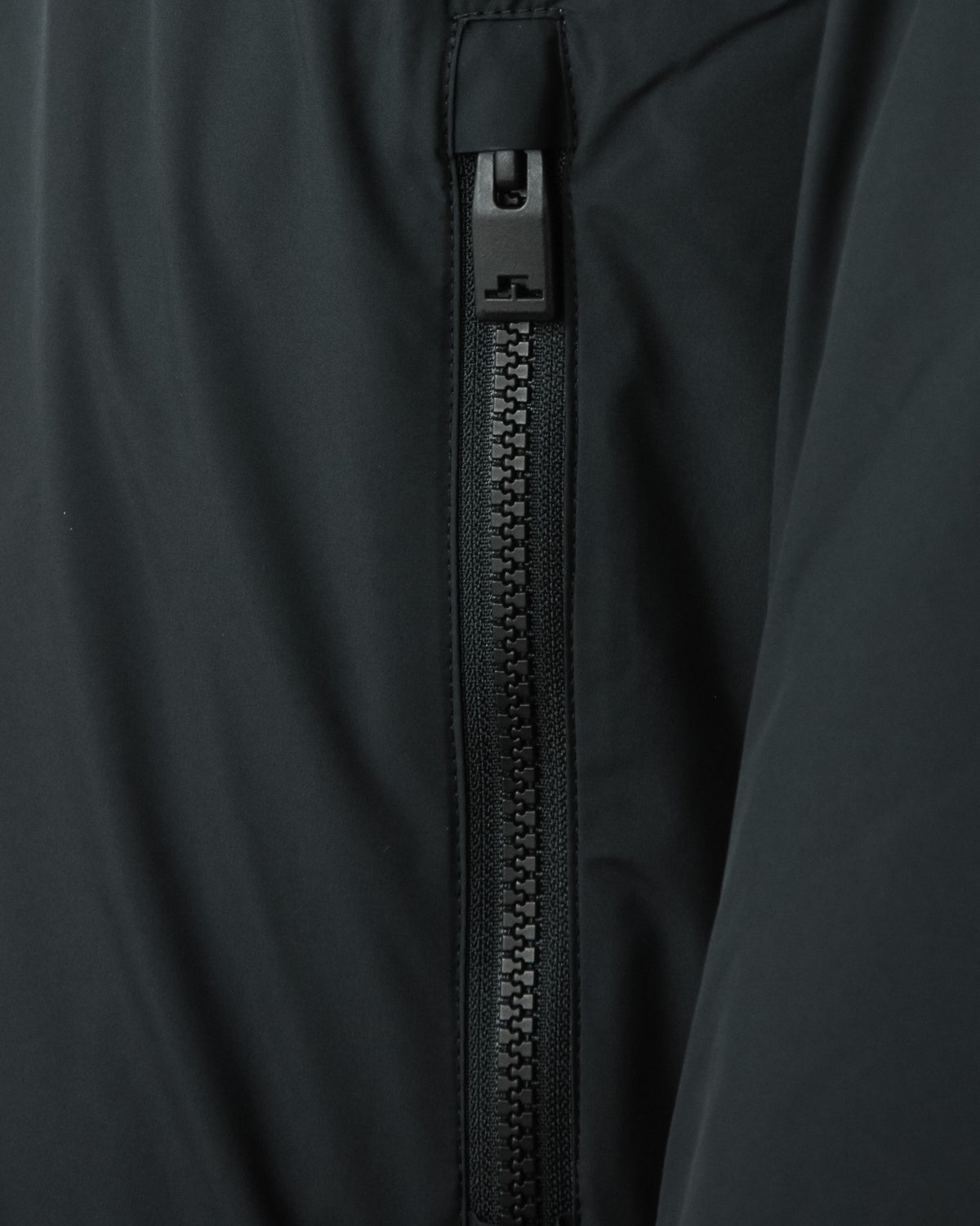 Close-up of black front zipper and top placket on down jacket