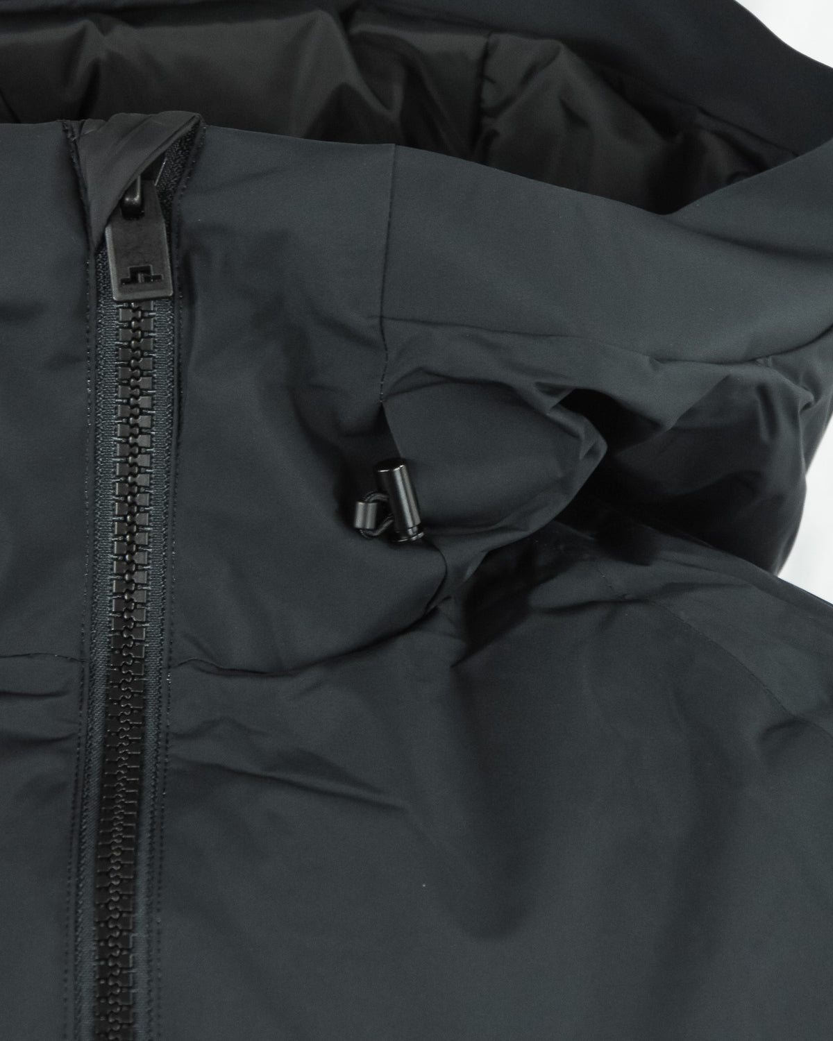 Side panel view of black down jacket with zipper track and pocket strap