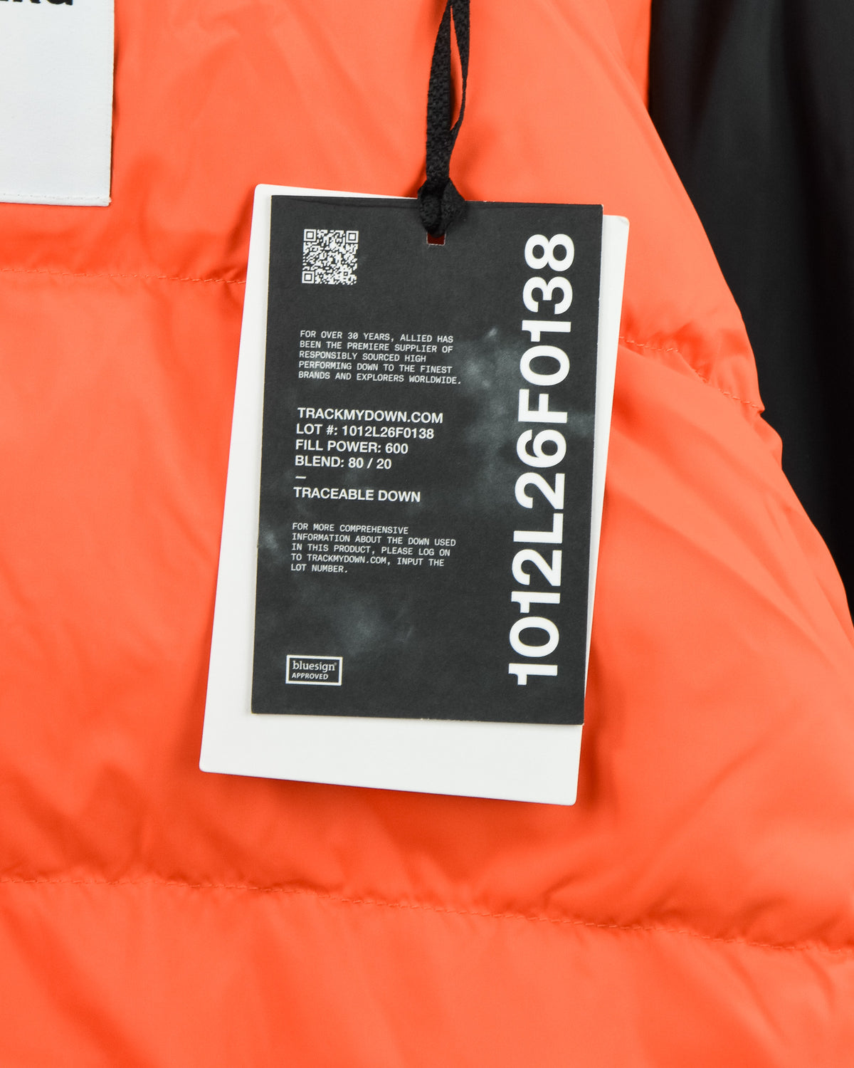 Down jacket with hanging brand tag, bright orange fabric