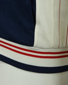 Striped ribbed hem on navy and cream track jacket with red and white lines