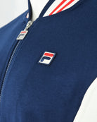 Navy track jacket with silver zipper and rectangular logo patch