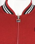 Red baseball track jacket neckline with striped collar and silver zipper pull.