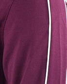 Close-up of purple track jacket fabric panel and textured seam stitching